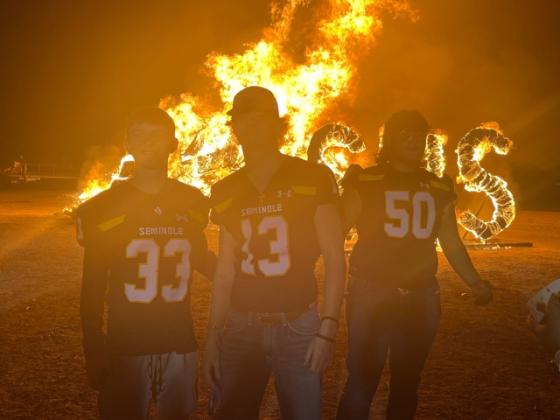 Football Players in front of burning sign