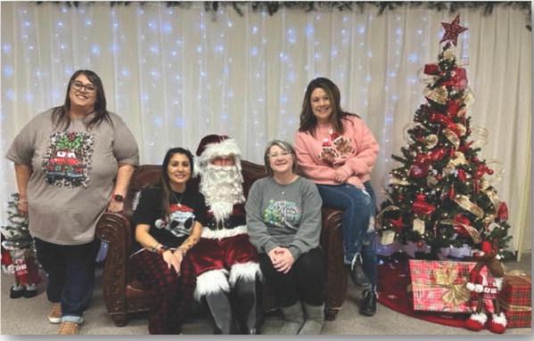 Staff at the Gaines County Library got to tell Mr. Claus what they wanted for Christmas this year during a recent visit. Pictured left to right are, Rebecca Saavedra, Bobbie Hernandez, Jamie Gonzales and Sabra Hall. (Contributed photo).