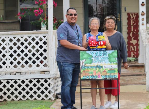 Johnny Gutierrez, representing the Seminole Sentinel presents Rosie Perez with the Sentinel’s Yard of the Weekhonor. Thefrontyardfeatures lush green grass and unique flower planters with beautiful flower arrangements growing. Pictured with Rosie(left)ishersister,ImeldaPerez. Sentinel photo/Jessenia Balderas)